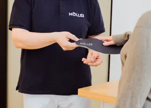 Eine Einlage wird an eine Kundin überreicht